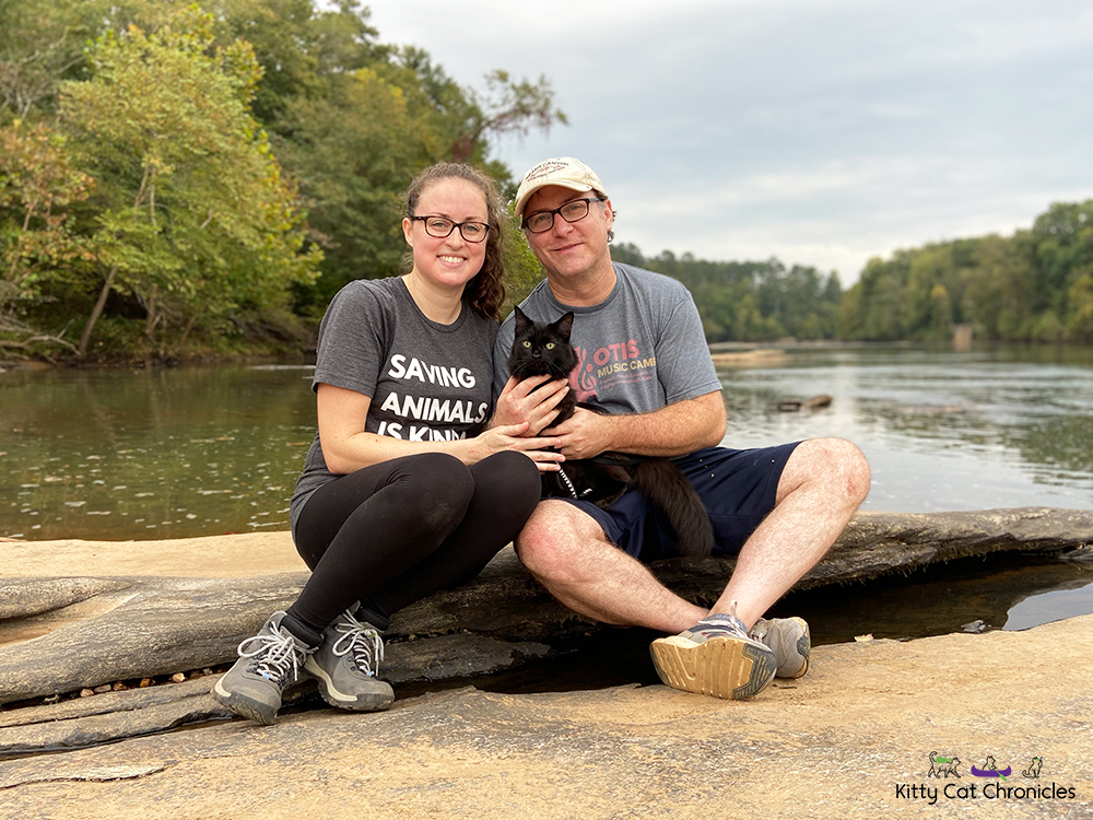 Family photo of a man, woman, and black cat at the Ocmulgee River