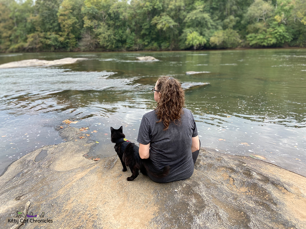 woman and black cat sitting by the Ocmulgee River